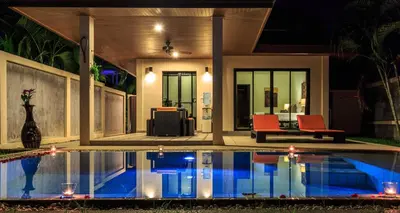 a swimming pool in front of a house at night at Phuket Pool Residence - Adults only in Rawai Beach