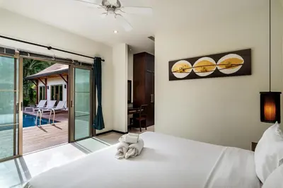 a bedroom with a bed and a view of a pool at Emerald Pool Villa Lush Villa On A Sunny Island in Nai Harn Beach