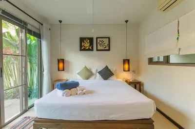 a bedroom with a white bed with teddy bears on it at Emerald Pool Villa Lush Villa On A Sunny Island in Nai Harn Beach