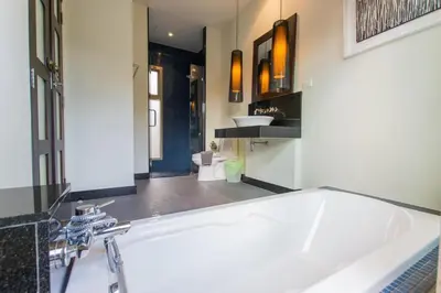 a bathroom with a white tub and a sink at Emerald Pool Villa Lush Villa On A Sunny Island in Nai Harn Beach