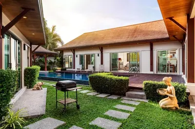 a backyard with a swimming pool and a house at Emerald Pool Villa Lush Villa On A Sunny Island in Nai Harn Beach