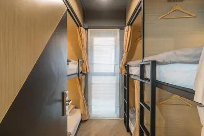 a small room with bunk beds and a door at Sleep Box Patong Hostel in Patong Beach