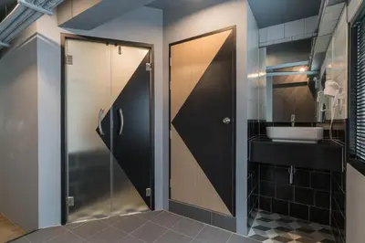 a bathroom with a glass door and a sink at Sleep Box Patong Hostel in Patong Beach