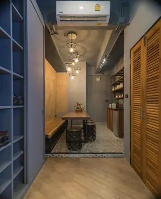 a hallway with a table and a bench in a room at Sleep Box Patong Hostel in Patong Beach