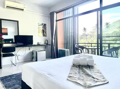 a hotel room with a bed and a large window at Mr.T Kamala Room in Kamala Beach