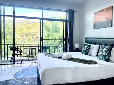 a bedroom with a large bed and a balcony at Mr.T Kamala Room in Kamala Beach