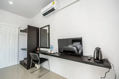 a bedroom with a desk with a bed and a chair at Mr.T Kamala Room in Kamala Beach