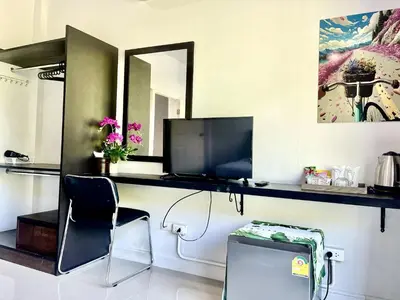 a room with a desk with a tv and a chair at Mr.T Kamala Room in Kamala Beach