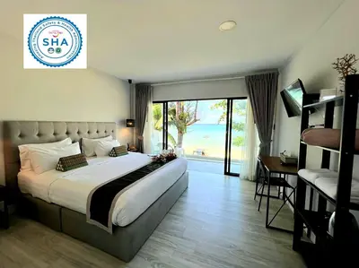 a hotel room with a large bed and a balcony at Thai Kamala Beach Front in Kamala Beach
