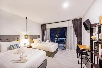 a hotel room with two beds and a balcony at Thai Kamala Beach Front in Kamala Beach