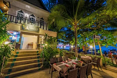 a restaurant with tables and chairs in front of a building at Thai Kamala Beach Front in Kamala Beach