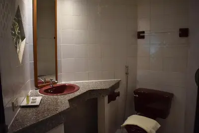 a bathroom with a sink and a toilet and a mirror at Karon Cafe Inn in Karon Beach