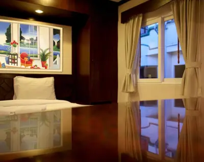 a bedroom with a bed and a window at Karon Cafe Inn in Karon Beach