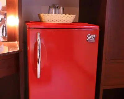 a red refrigerator with a basket on top of it at Karon Cafe Inn in Karon Beach