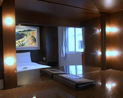 a small room with a bed and a mirror at Karon Cafe Inn in Karon Beach