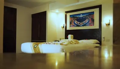 a bed in a room with a painting on the wall at Paradise Inn in Karon Beach
