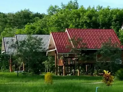 a house with a red roof in a field at Bang Hon Homestay in Ko Yao Noi