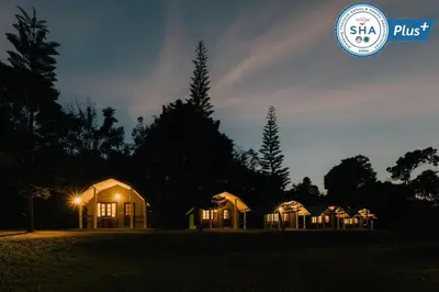 a row of houses at night with a rainbow in the sky at Phuket Campground in Mai Khao Beach