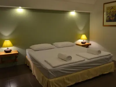 a bedroom with a large white bed with two lamps at Phuket Campground in Mai Khao Beach