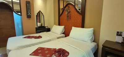 two beds in a hotel room with bows on them at Suuko Villas in Chalong
