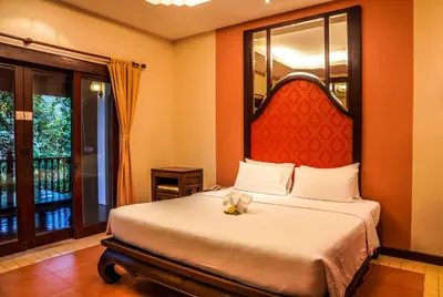 a bedroom with a large bed with a red headboard at Suuko Villas in Chalong