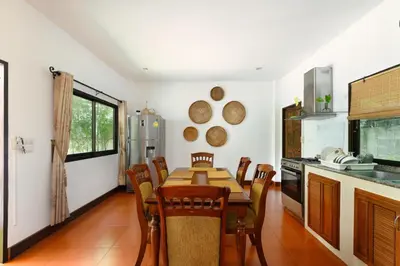 a kitchen with a table and chairs in a room at Beachfront pool villa in Kamala Beach