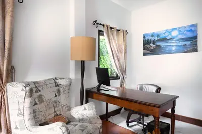 a room with a desk and a chair with a computer at Beachfront pool villa in Kamala Beach