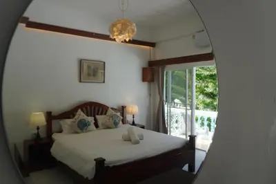 a bedroom with a bed and a mirror at Residy Retreat x Baan Suan Villa in Patong Beach