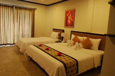 two beds in a hotel room with flowers on them at Phukamala Suite in Kamala Beach