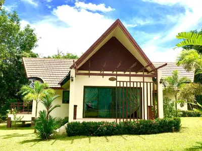 a house with a large window in a yard at Kannapat House in Ban Nong Thale
