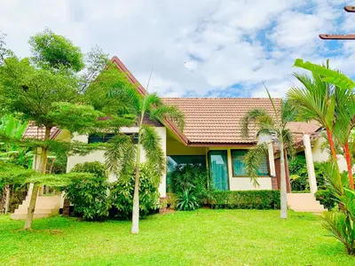 a house with palm trees in front of it at Kannapat House in Ban Nong Thale
