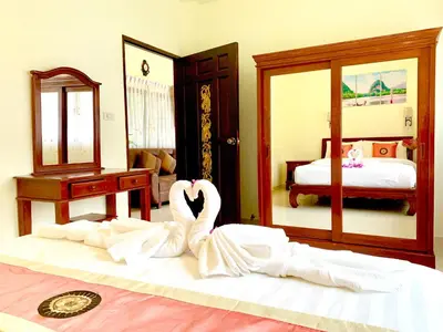 two swans laying on a bed in a bedroom at Kannapat House in Ban Nong Thale