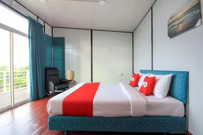 a bedroom with a large bed with red pillows at Happy Mountain Airport Resort in Nai Yang Beach