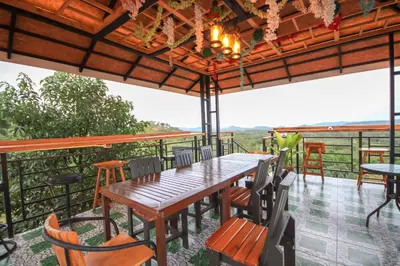 a table and chairs on a deck with a view at Happy Mountain Airport Resort in Nai Yang Beach