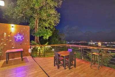a wooden deck with a table and chairs on it at Happy Mountain Airport Resort in Nai Yang Beach