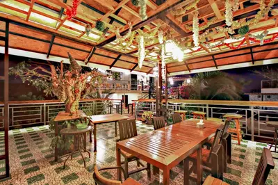 a restaurant with wooden tables and chairs and a ceiling at Happy Mountain Airport Resort in Nai Yang Beach