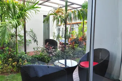a patio with chairs and a table and plants at Phu NaNa Boutique Hotel - SHA Plus in Rawai Beach