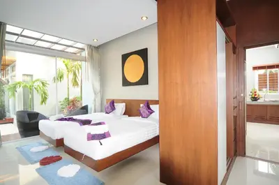 a bedroom with two beds and a large window at Phu NaNa Boutique Hotel - SHA Plus in Rawai Beach