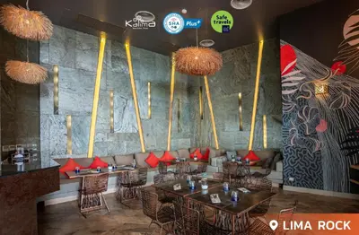 a restaurant with tables and chairs with red pillows at Kalima Resort and Spa in Patong Beach