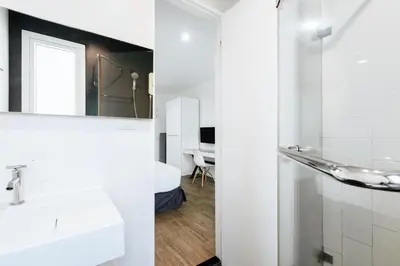 a white bathroom with a sink and a mirror at Blu Monkey Bed & Breakfast Phuket in Phuket Town