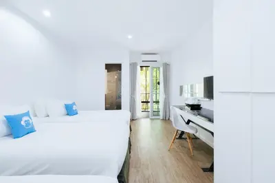 a bedroom with two beds and a desk at Blu Monkey Bed & Breakfast Phuket in Phuket Town