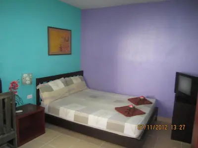 a small bedroom with a bed and a tv at Popeye Guesthouse in Ao Nang Beach