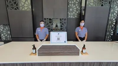 two men wearing masks standing next to a table with a sign at Zenseana Resort & Spa - Patong, Phuket in Patong Beach
