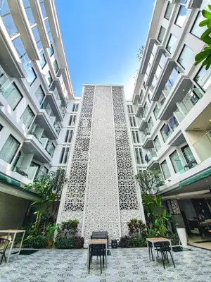 a tall building with chairs in front of it at Zenseana Resort & Spa - Patong, Phuket in Patong Beach