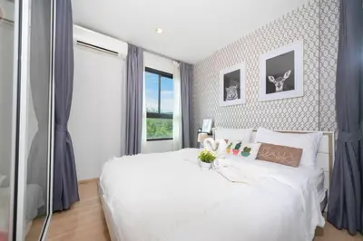 a bedroom with a white bed and a window at Bangtao,Layan beach apartment in Bang Tao Beach