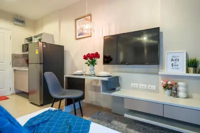a room with a kitchen with a desk and a tv at Bangtao,Layan beach apartment in Bang Tao Beach