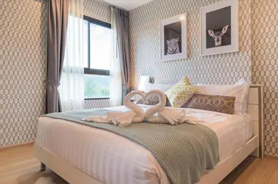 a bedroom with a bed with two swans on it at Bangtao,Layan beach apartment in Bang Tao Beach