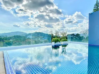 a swimming pool with a view of the mountains at The Palms Residence - SHA Extra Plus in Phuket Town