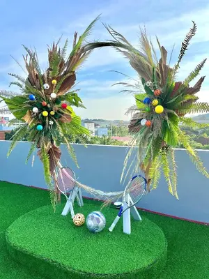 two palm trees and tennis rackets and balls on a balcony at The Palms Residence - SHA Extra Plus in Phuket Town