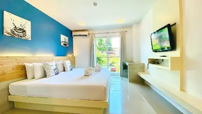 a bedroom with a large bed and a tv at The Palms Residence - SHA Extra Plus in Phuket Town